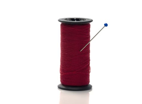 bobbin with red cotton on white isolated background