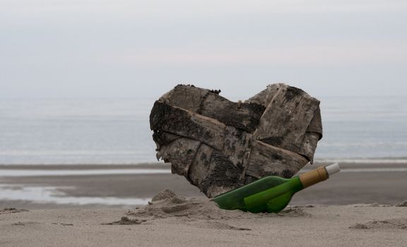 green bottle post and a lost heart on the beach