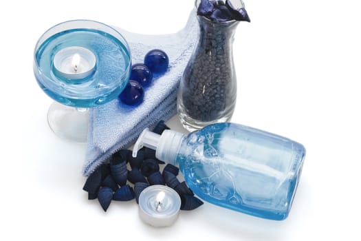 body care liquid, candle and a blue pebble for spa treatment