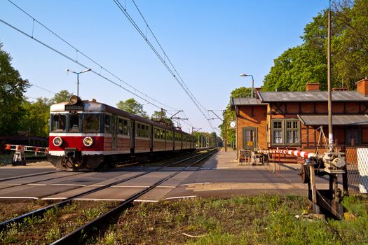 Passenger train passing the railroad crossing with the road
