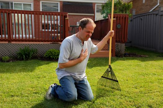 man having a heart attack chest pains while doing yard work