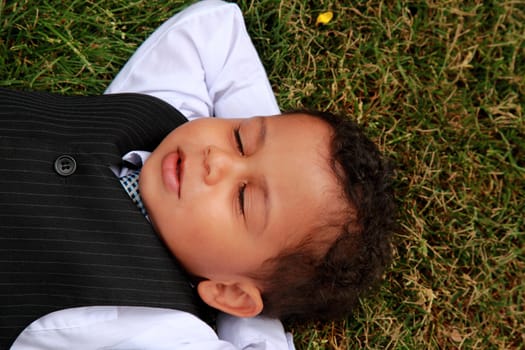 young boy lying and relaxing on the grass peaceful