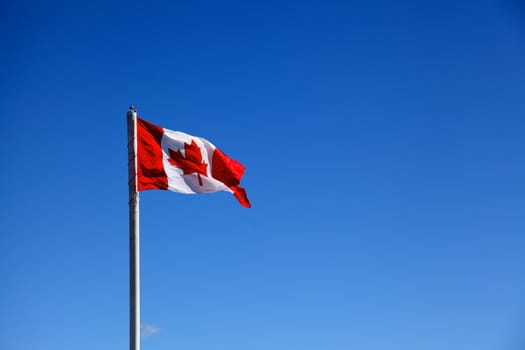 canadian flag against blue sky