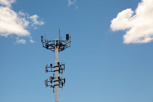 communications tower with wireless receivers against blue sky