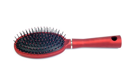 An image of a red hairbrush on white background