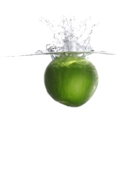 Green apple falling in water