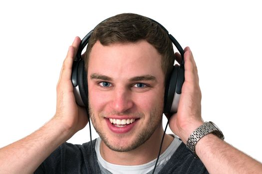 Close up of face of young man in grey t-shirt listening to music with earphones