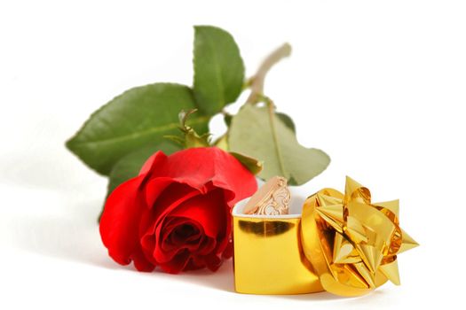 An image of red rose and jewelry