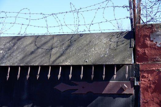 Old metal gate with a barbed wire