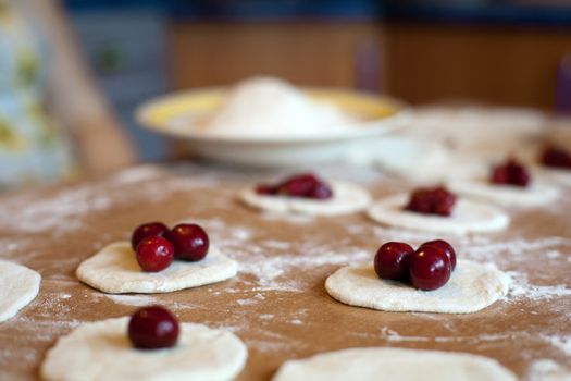 An image of raw dumplings with fresh red cherries 