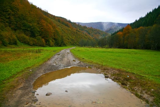 An image of a wet road in the mountains