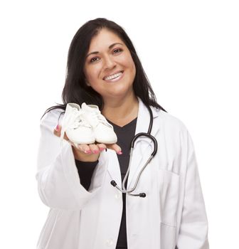 Attractive Hispanic Female Doctor or Nurse Holding Out Baby Shoes Isolated on a White Background.