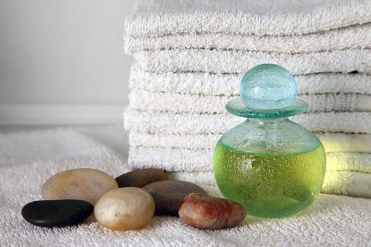 Blue bottle with massage oil on a background of towels