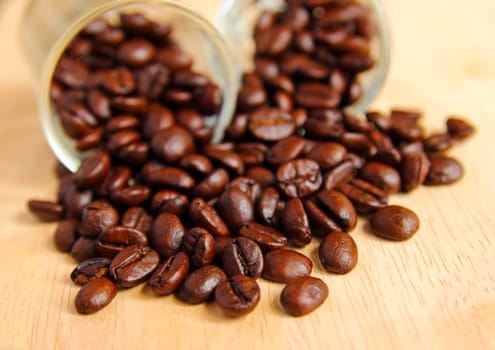 Coffee beans in glasses on wooden background