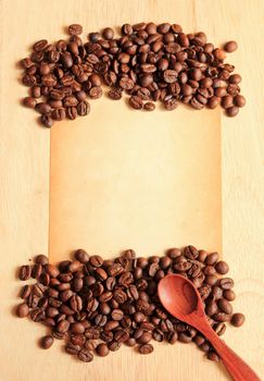 Coffee beans and spoon with old paper on the wooden background