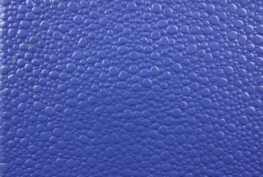 A background of a blue leather with abstract design on it.