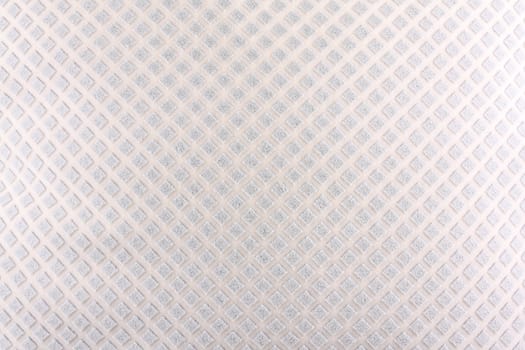 A background of a white fabric with an abstract design of diamond shapes on it.