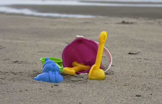 plastic toys on the beach with bucket sppon and rake