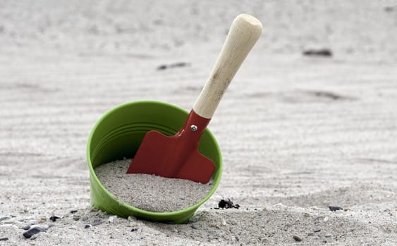red and green shovel and bucket on the beach