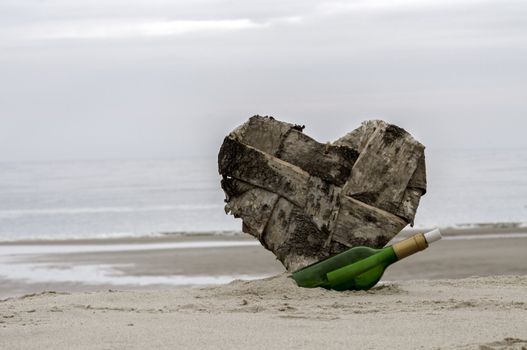 green bottle post and a lost heart on the beach