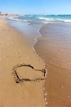 drawing a heart on sandy beaches of the Mediterranean