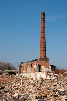 old factory ruins with one brick smoke stack