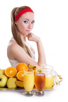 Sporty woman sitting with fresh juices and fruits