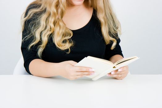 A girl with long blond hair reading a book