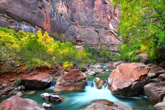 Waterfall on the Virgin River flows through large boulders in Zion Canyon.
