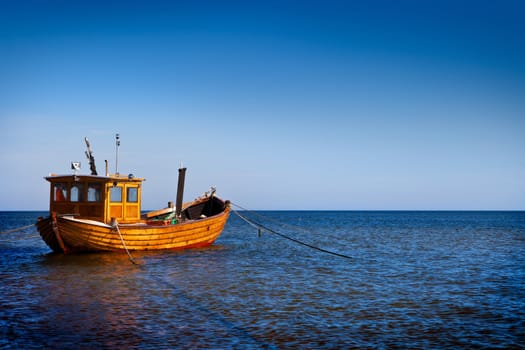 Fishing boat floating on the water, blue sea and sky with copyspace