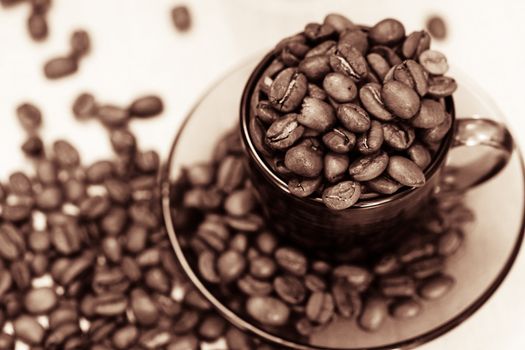 An image if coffee cup and spilled coffee beans closeup