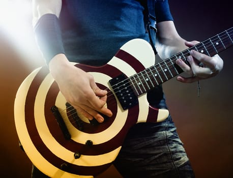 An image of a man playing electrical guitar.