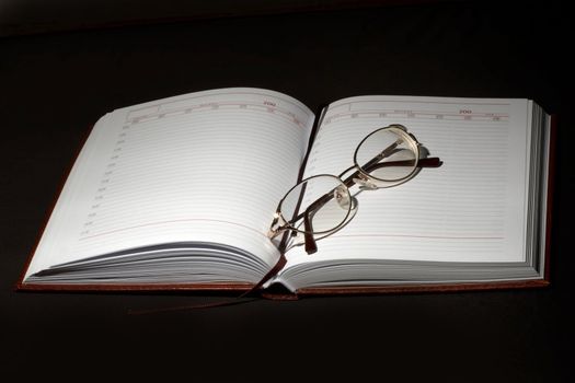 An image of notebook and glasses