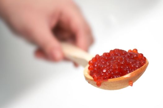 Red caviar in a wooden spoon