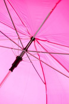 A large pink umbrella is isolated on a pure white background