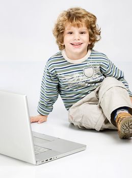 Blue curl hair boy seating near laptop