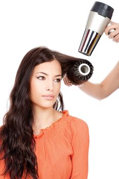 hairdresser combing and dry the hair of a woman, isolated on white background