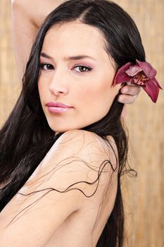 Pretty wet woman with red orchid in hair