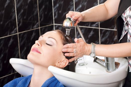 Hairdresser washing hair of customer