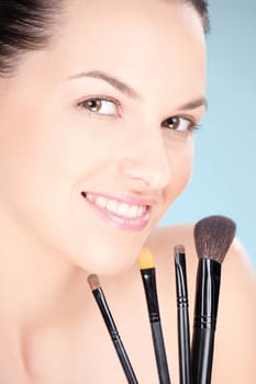 Pretty woman holding set of make up brushes