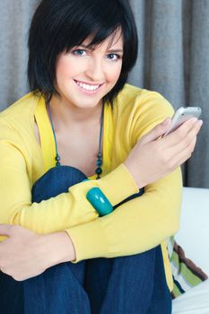 Pretty girl using mobile phone at home