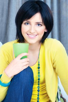 Pretty young woman holding glass of water at home