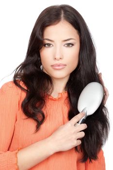 Portrait of a pretty woman combing her long black hair, isolated on white background