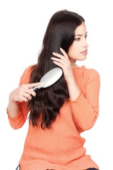pretty woman combing her long black hair, isolated on white background