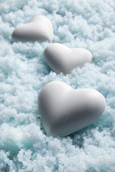 Blank white Hearts on Snow Background. Small Depth of Field. Blue tinted