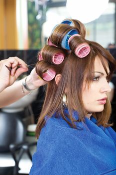 hairstylist pinching client's curlers