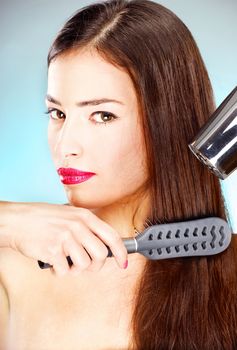 pretty woman with long hair holding blow dryer and comb