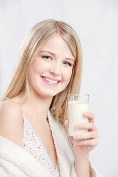 Smiling blond hair woman holding glass of milk