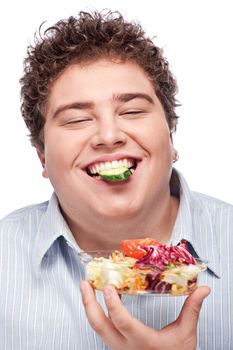 Happy young chubby man with fresh salad, isolated on white