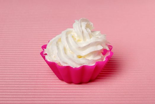 Portion of whipped cream over pink background. Shallow DOF